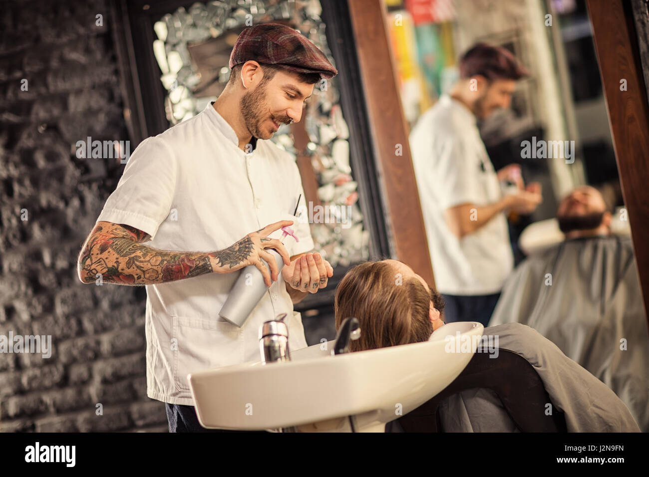 Hairstylist lave-tête d'homme avec de la barbe barbier Banque D'Images