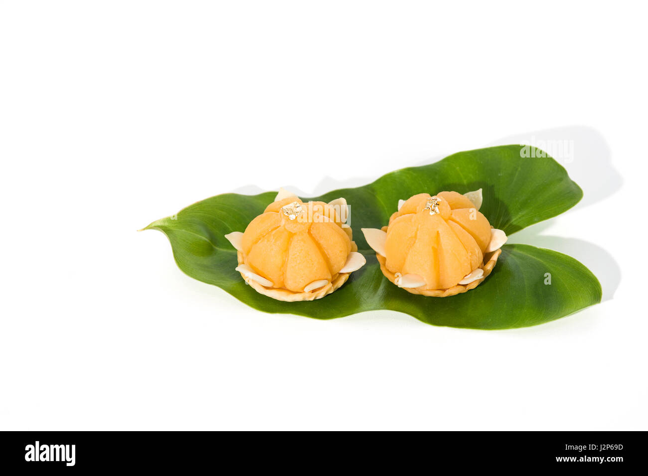 Dessert jaune royal Thai cuisine décorée avec des feuilles vertes sur fond blanc solide Banque D'Images