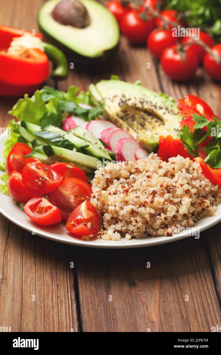 Bol bouddha avec mélange de légumes, quinoa sur fond de bois Banque D'Images