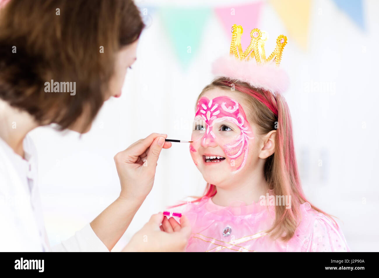 La peinture du visage de petite fille. Princesse et conte de thème d'anniversaire avec la peinture pour le visage de l'artiste et costume pour enfant d'âge préscolaire. Enfants célébrant Hallow Banque D'Images