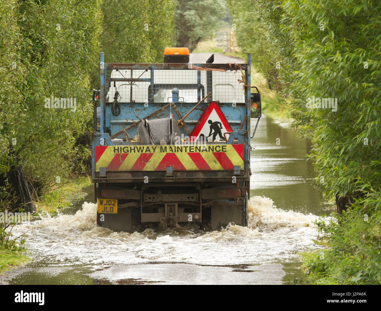 16 juillet 2012 - Les véhicules roulant dans l'inondation sur les niveaux de Somerset sur la route entre Glastonbury et Godney Banque D'Images