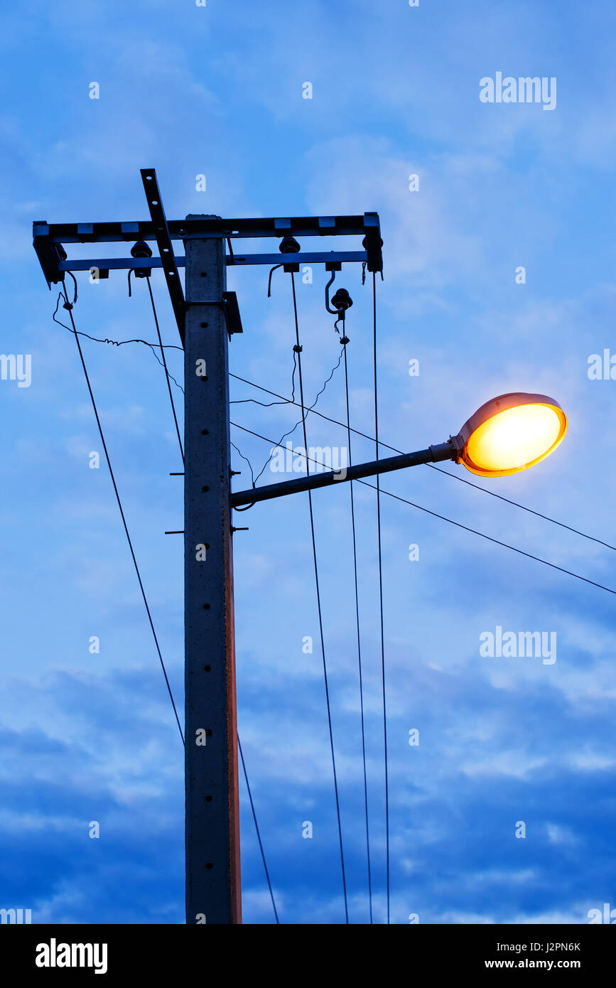 L'éclairage sur le béton poteau d' électricité en soirée Banque D'Images