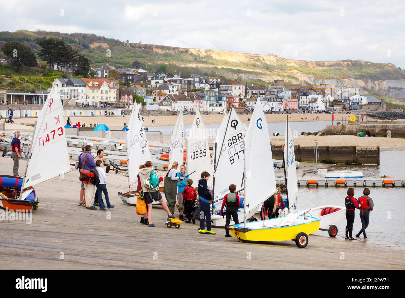 Les enfants faire du sport - les enfants à apprendre à naviguer en dériveurs, Lyme Regis Harbour, Dorset England UK Banque D'Images