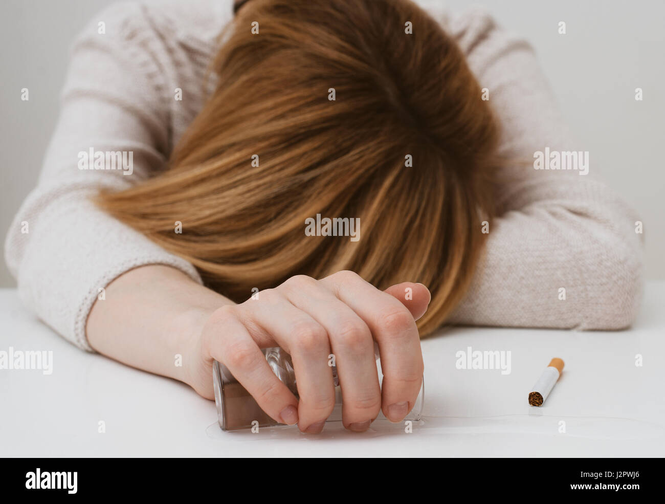 Femme ivre dormir sur la table. L'alcoolisme féminin. Banque D'Images