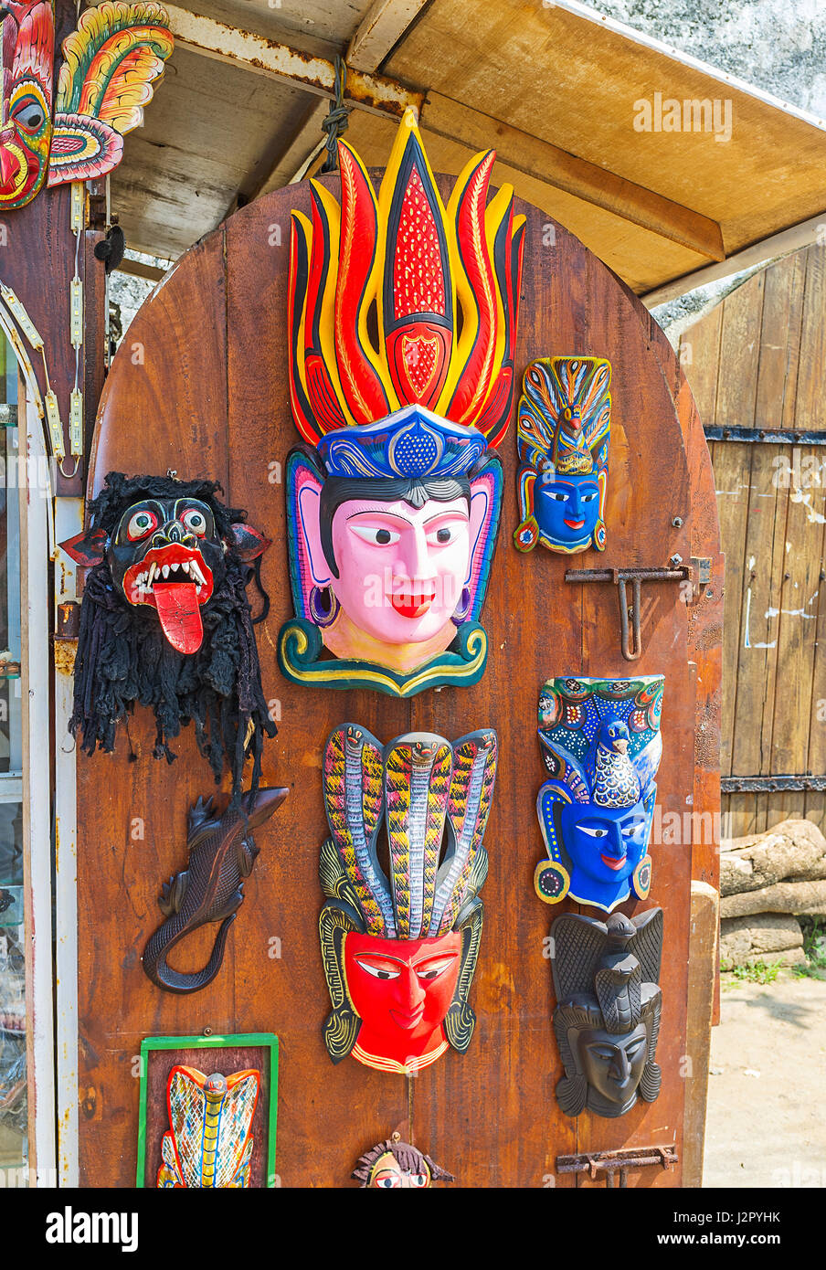 Les masques en bois faits à la main sur la porte de cabine de souvenirs en Galle Fort, Sri Lanka. Banque D'Images