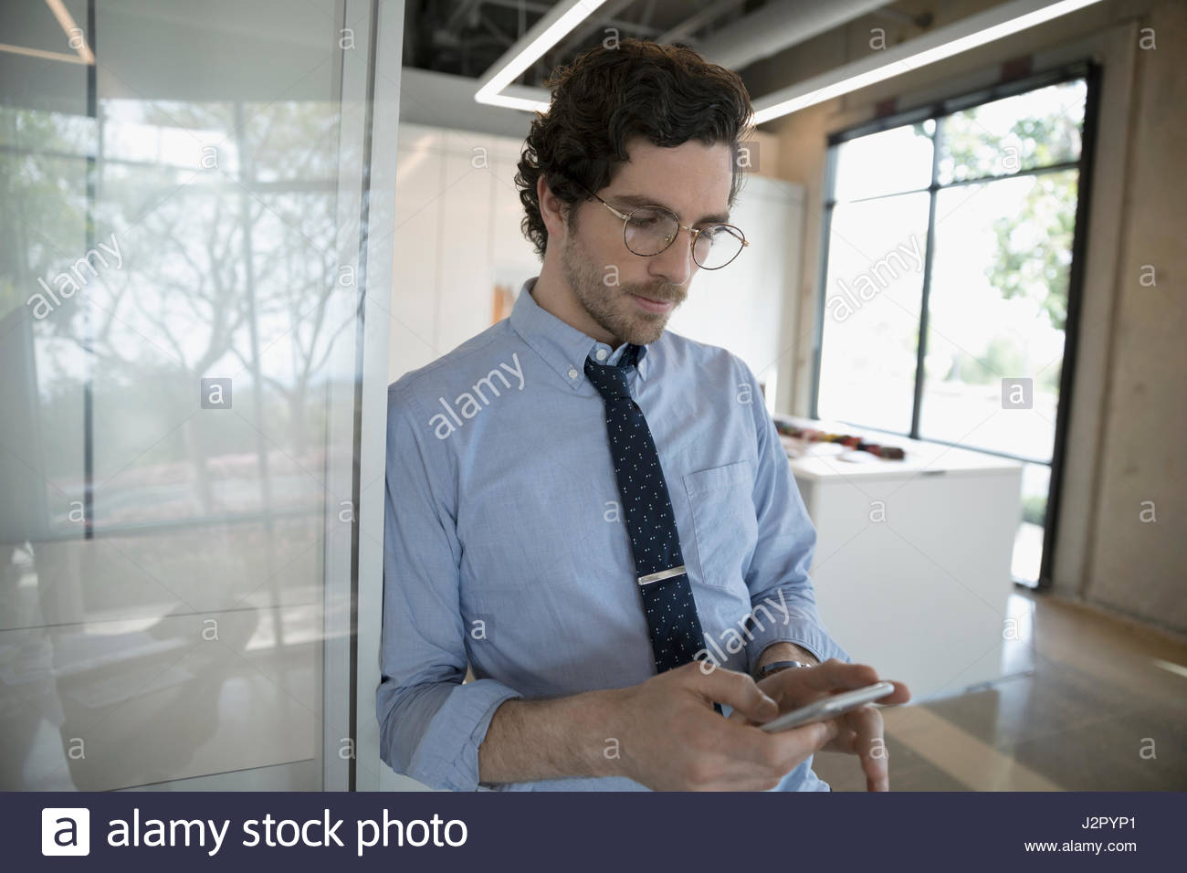 Businessman texting with smart phone dans la salle de conférence Banque D'Images