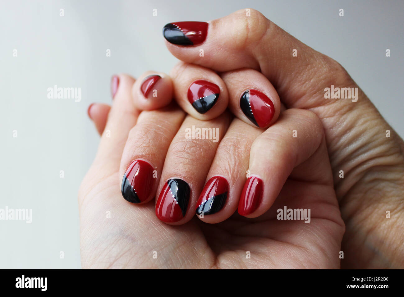 Rouge noir délicate beauté manucure avec vernis gel sur un mur blanc  background Photo Stock - Alamy