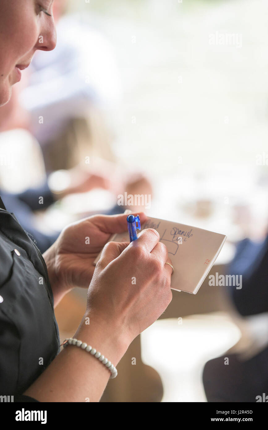 Serveuse de restaurant en prenant un ordre écrit une ordonnance prenant une commande du client des services alimentaires services alimentaires Banque D'Images