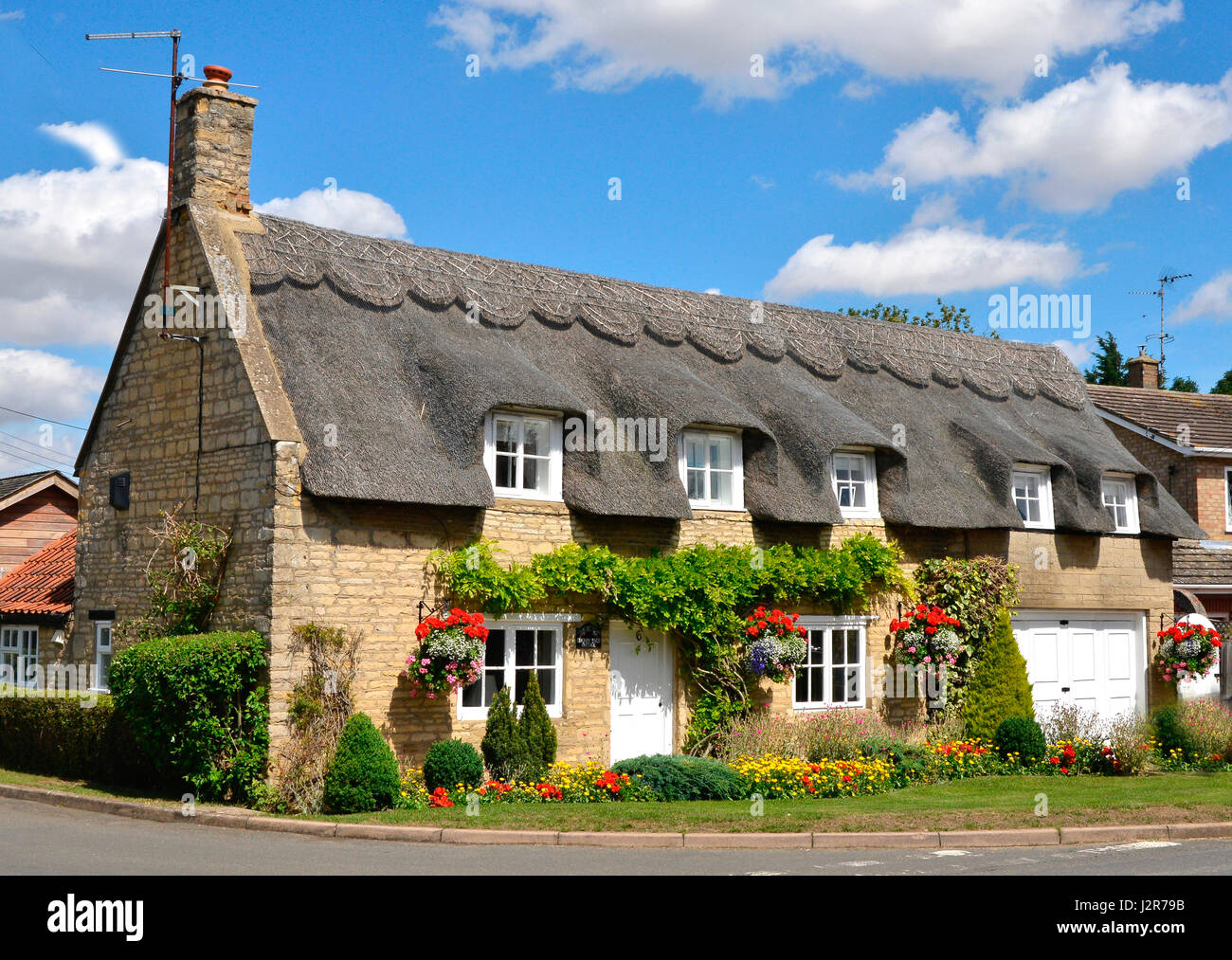 Thatched cottage anglais traditionnel avec jardin coloré Banque D'Images