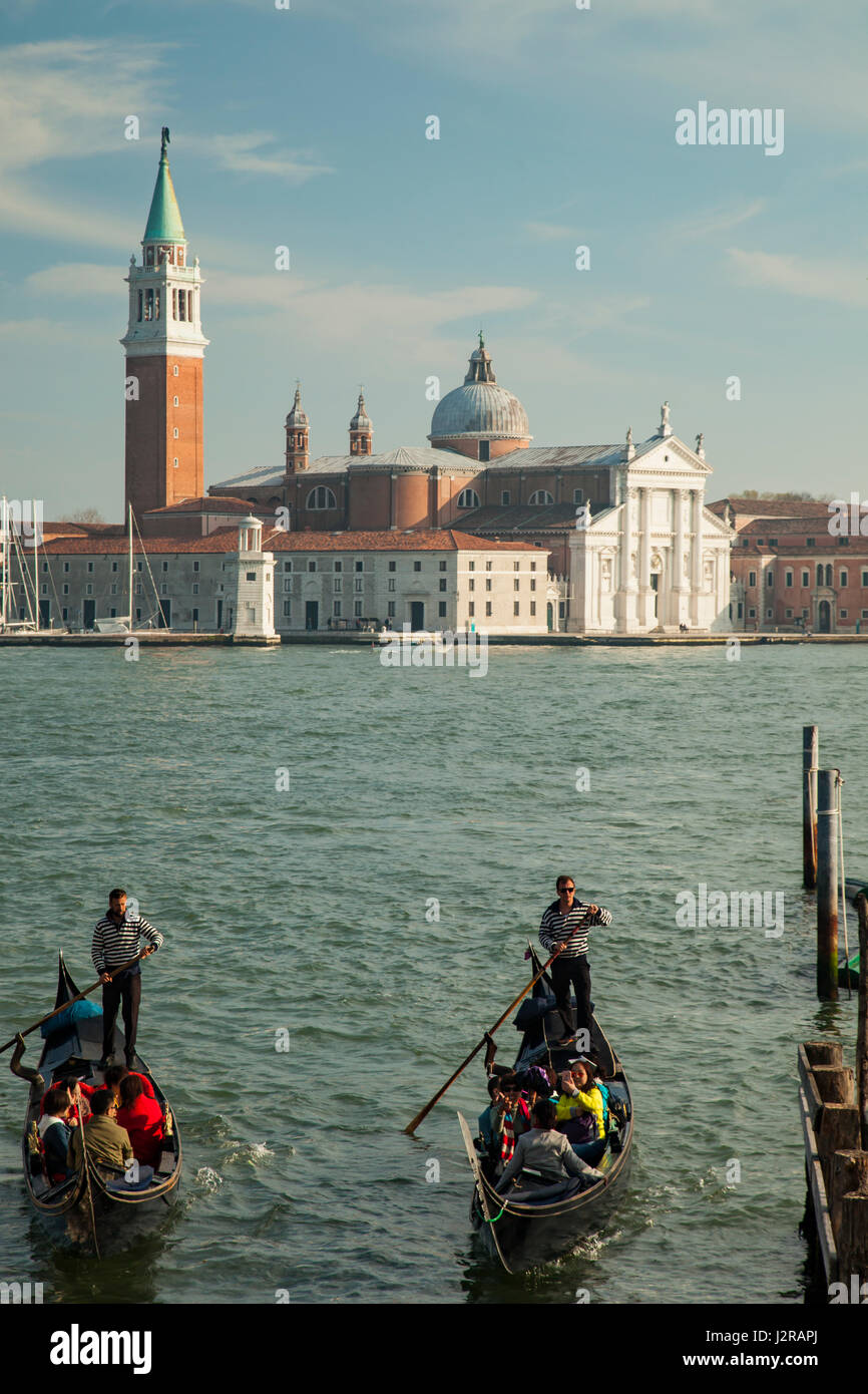 Gondoles entrant dans quartier de San Marco à Venise. San Giorgio Maggiore Église dans la distance. Banque D'Images