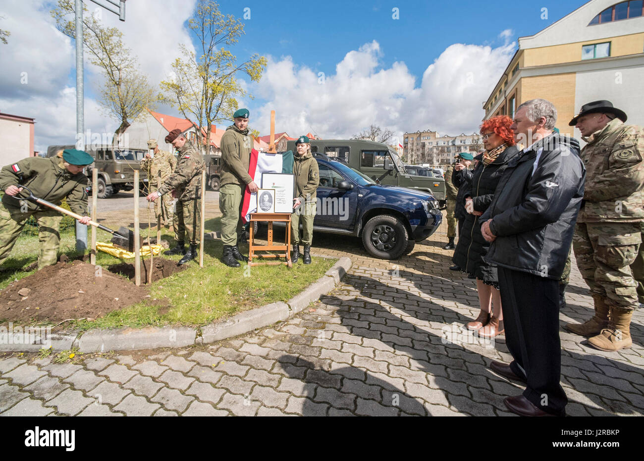 Un Mundurowej Centrum Edukacji plantes étudiant un chêne au cours d'une cérémonie en l'honneur Henryk Bartoszewicz, un officier de cavalerie polonaise assassinés durant le massacre de Katyn en 1940. L'académie militaire local à Elk, Pologne, a invité le groupe de combat du lieutenant-colonel commandant Pologne Steven Gventer (à droite) et ses soldats pour afficher leur équipement de combat et de petit calibre ainsi que l'armée polonaise, la 15ème Brigade Mécanisée de l'exposition statique lors de sa journée portes ouvertes annuelle le 22 avril. (U.S Army photo par le Sgt. 1re classe Patricia Traiter/libérés) Banque D'Images