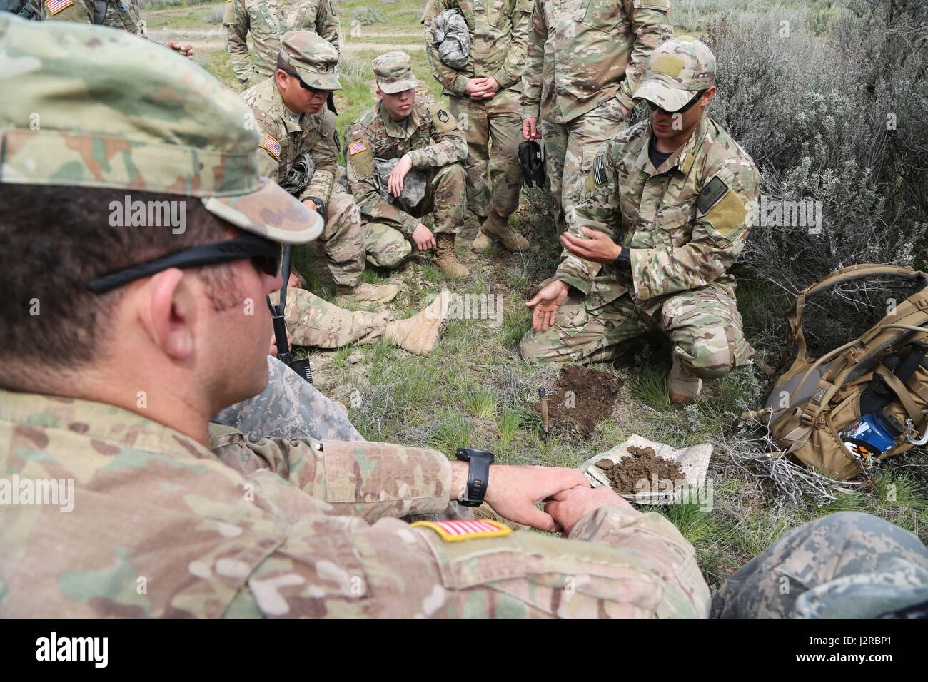 Le personnel DE SERE instruit les soldats du 20e Commandement CBRNE sur le creusement de trous en H pour les feux discrets et les techniques de survie au Yakima Training Center, Washington, le 25 avril 2017, mettant l'accent sur les compétences de survie dans le désert et la préparation sur le terrain. Banque D'Images