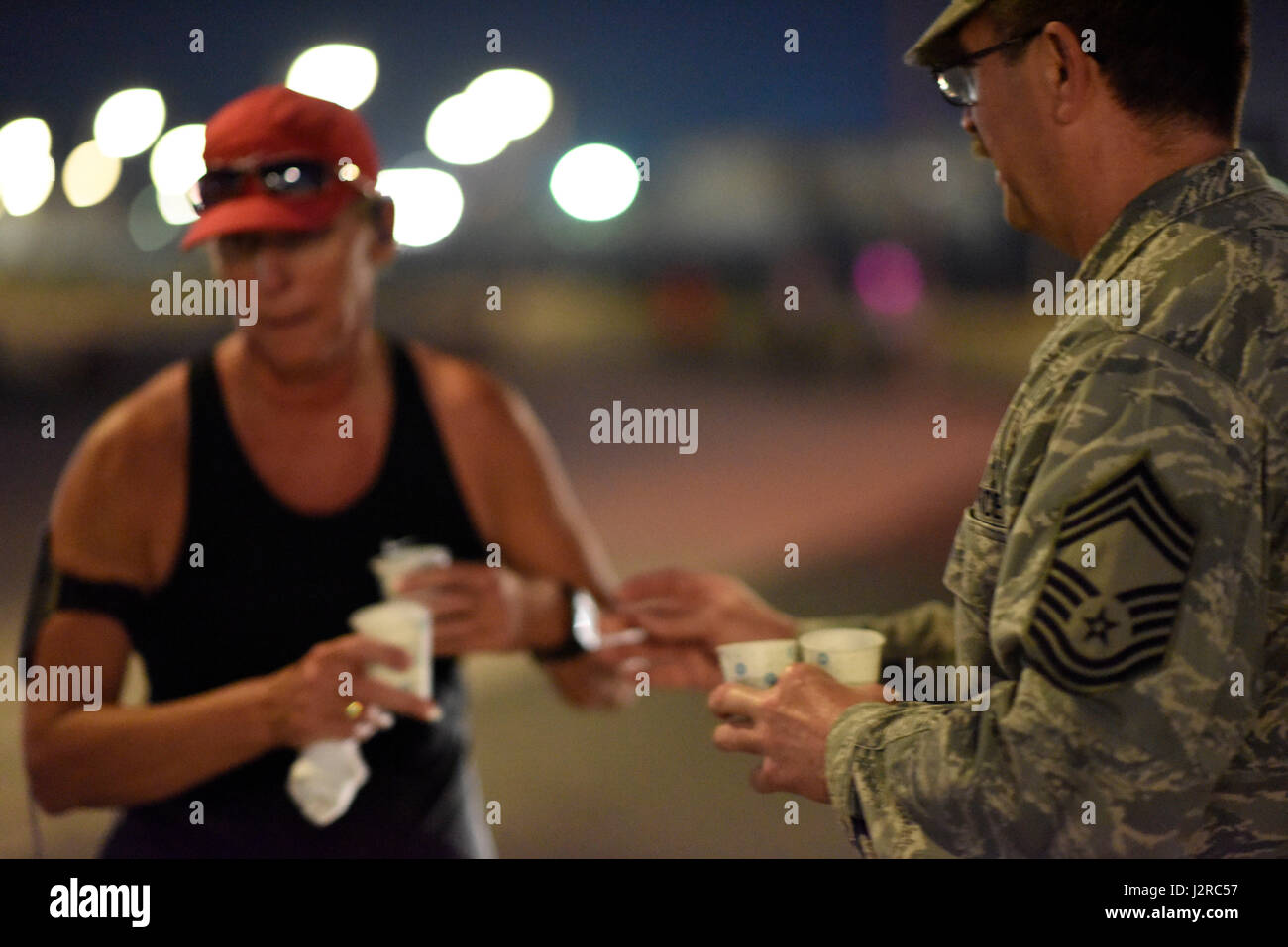 Un chef de l'US Air Force le Master Sergeant les mains hors de l'eau à une exécution d'un participant 26,2 milles au cours Al Udeid Air Base, au Qatar, le 22 avril 2017. Ce cours a été une ombre courir le marathon de Boston, de lieu pour commémorer les victimes de l'attentat du Marathon de Boston 2013. (U.S. Photo de l'Armée de l'air par la Haute Airman Cynthia A. Innocenti) Banque D'Images