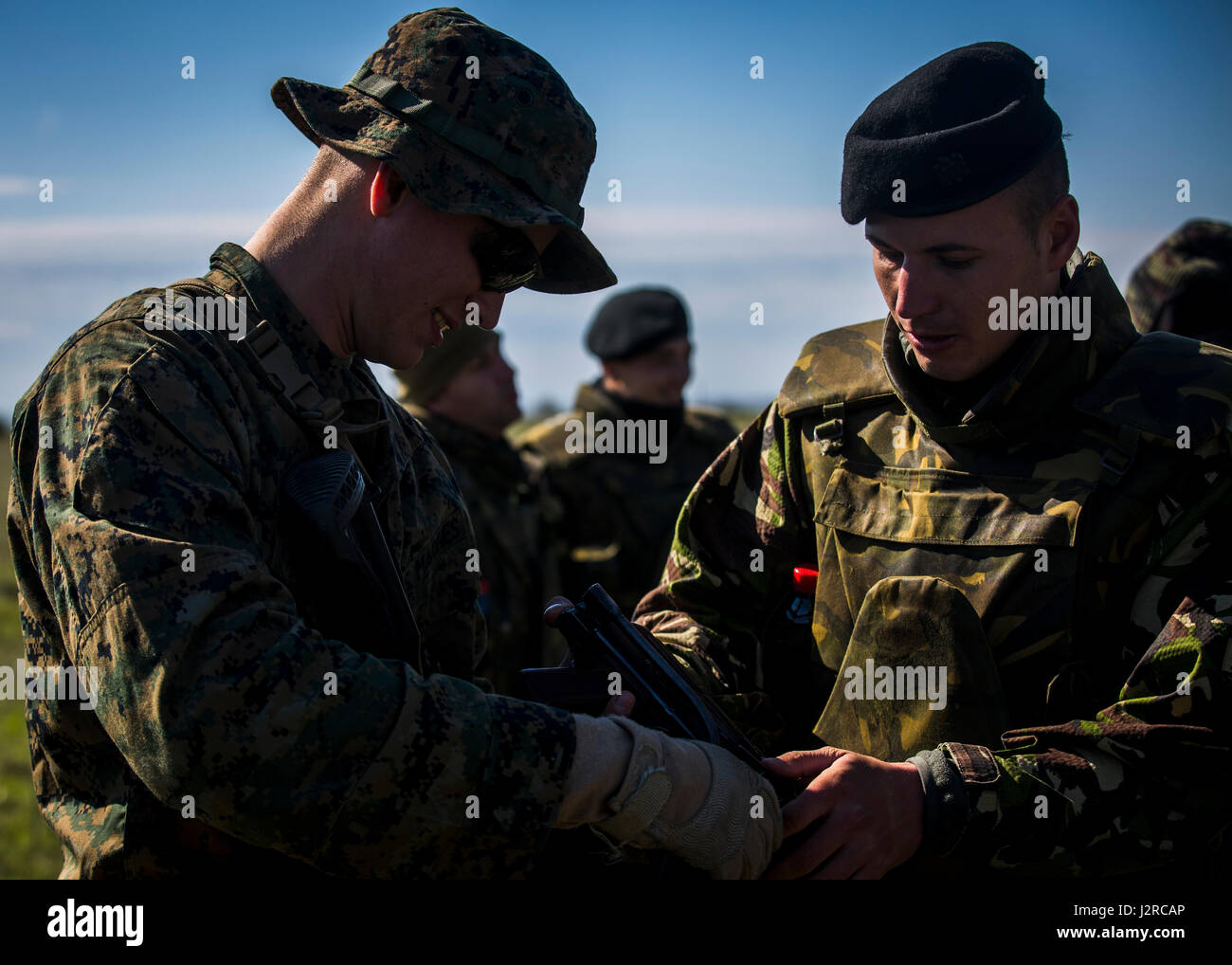 La Marine américaine lance le Cpl. Philippe McShurley, un carabinier avec force de rotation Maritime Europe 17.1, apprend à propos de l'AK-47 par un soldat roumain au secteur d'entraînement Babadag, Roumanie, 24 avril 2017. MRF-E charge Exercice Platinum Eagle 17.2 pour renforcer les relations avec les pays partenaires. Tour de présence des États-Unis dans la région de la mer Noire augmente de manière significative le niveau de coopération entre les forces armées dans des activités de formation et d'exercices qui développent les capacités militaires et l'interopérabilité. (U.S. Marine Corps photo par Lance Cpl. Sarah N. Petrock) Banque D'Images