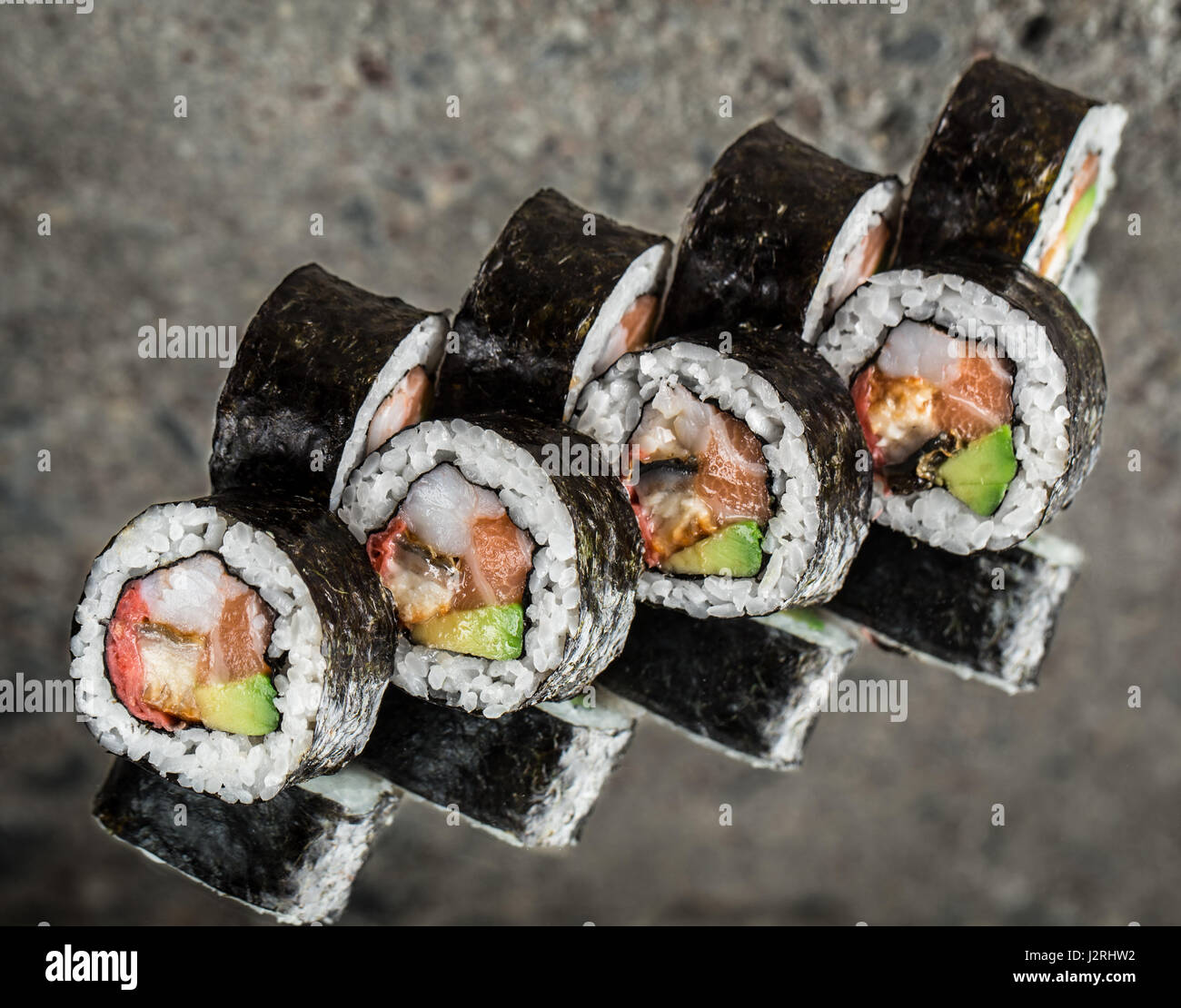 Sushi roll avec saumon, crevettes et avocat Banque D'Images