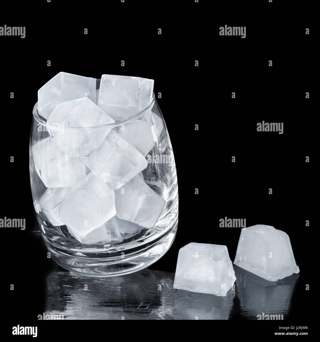 Des cubes de glace dans un verre sur un fond noir. Dans un carré de culture. Banque D'Images