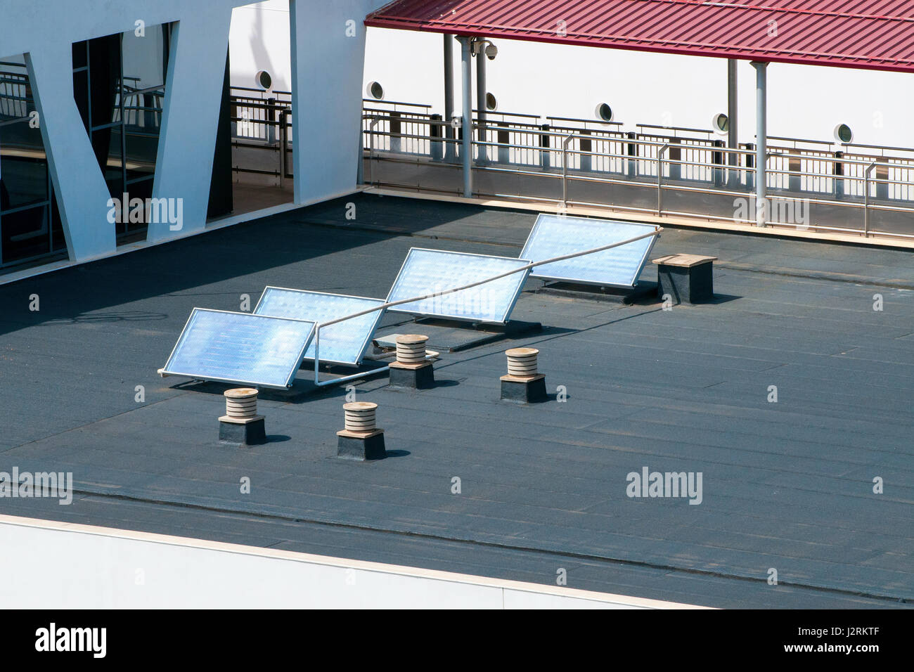 Quatre panneaux solaires sur le toit fixe qui absorbent la lumière du soleil comme source d'énergie pour produire de l'électricité ou de la chaleur Banque D'Images