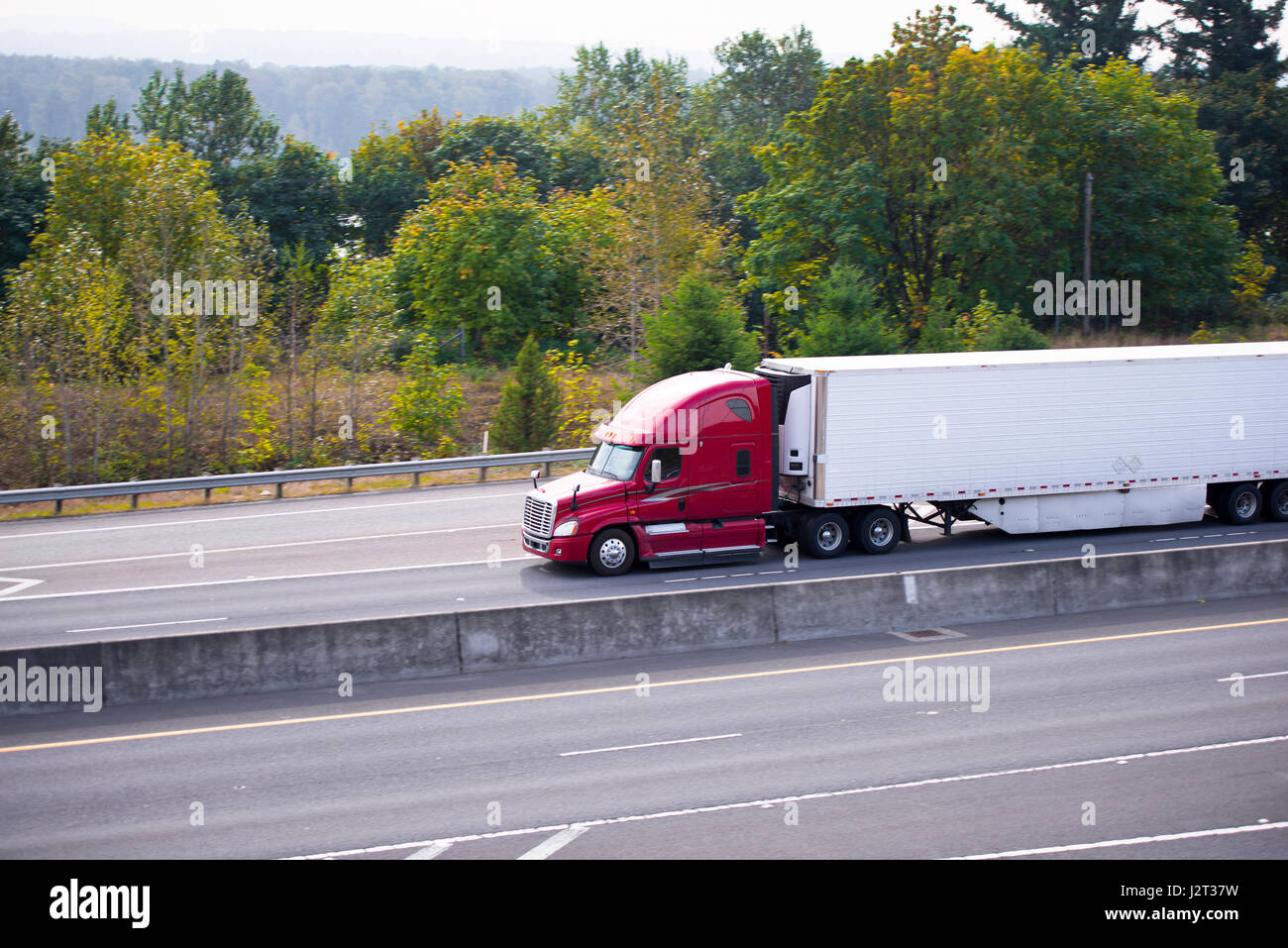 L'expression moderne de camions lourds spectaculaires avec semi remorque frigorifique et carrosserie aérodynamique avec spoilers sur l'autoroute avec un Banque D'Images