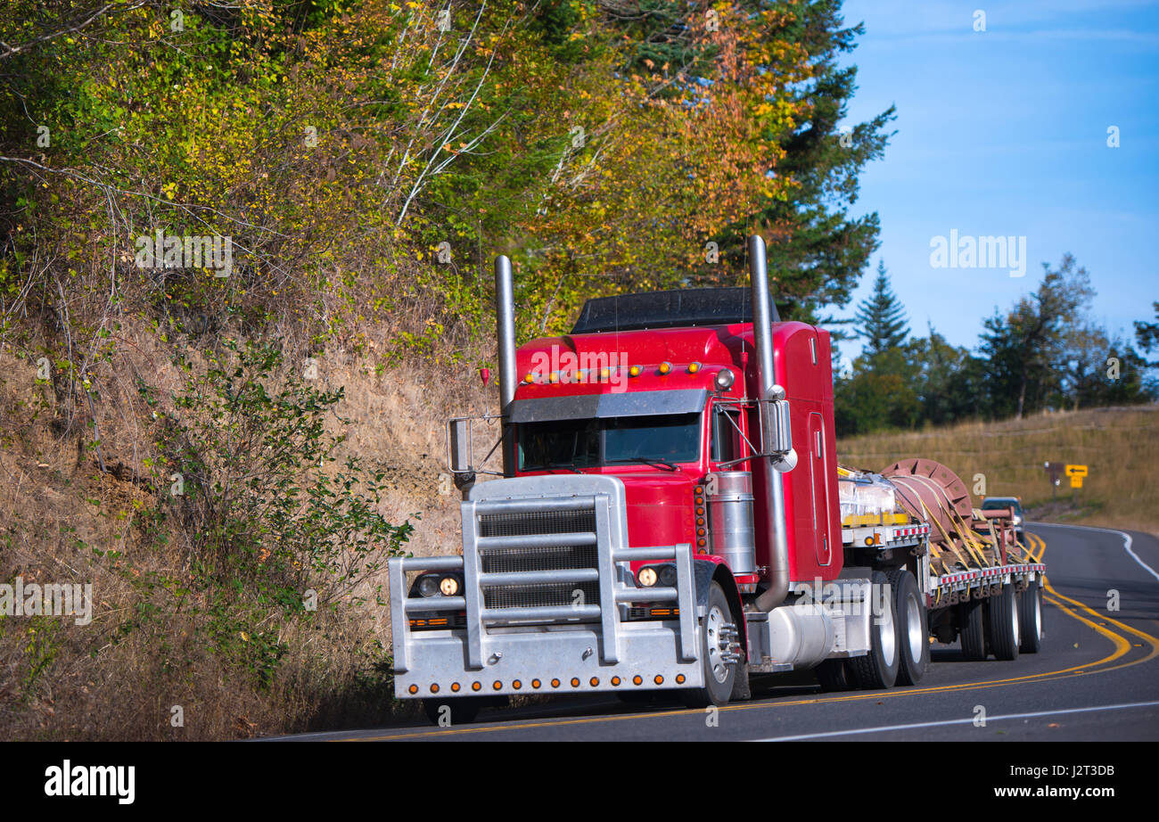 Heavy puissant rouge vif énorme classique professionnel gros camion semi truck avec une grille de protection épais et échappement haut et pas en bas trailer Banque D'Images
