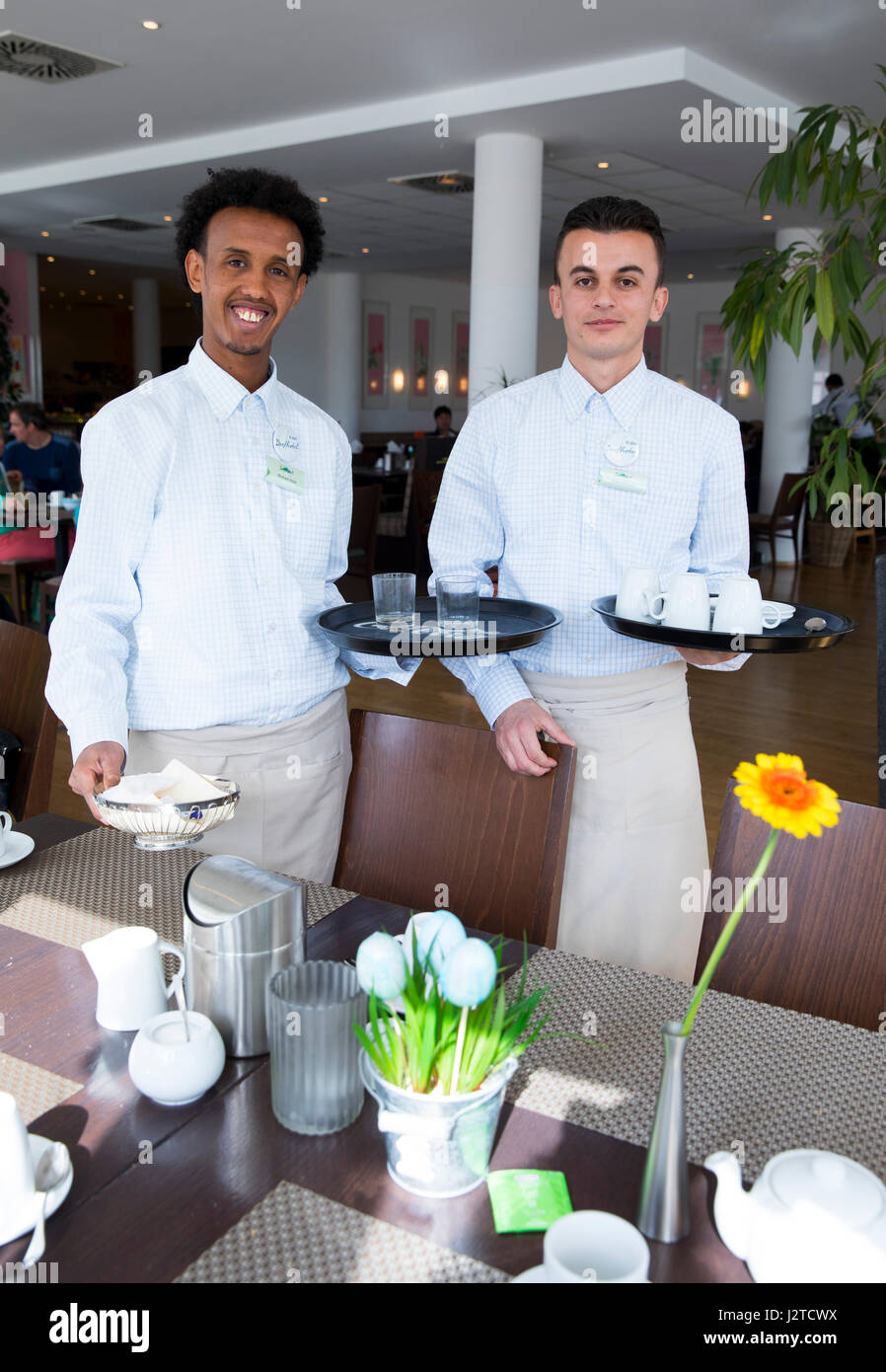 Les deux réfugiés d'Albanie (r) et de l'Érythrée travailler au restaurant  de l'hôtel de ville de Paris sur l'île de Sylt de la mer du Nord, Gemrany,  20 avril 2017. Le programme "