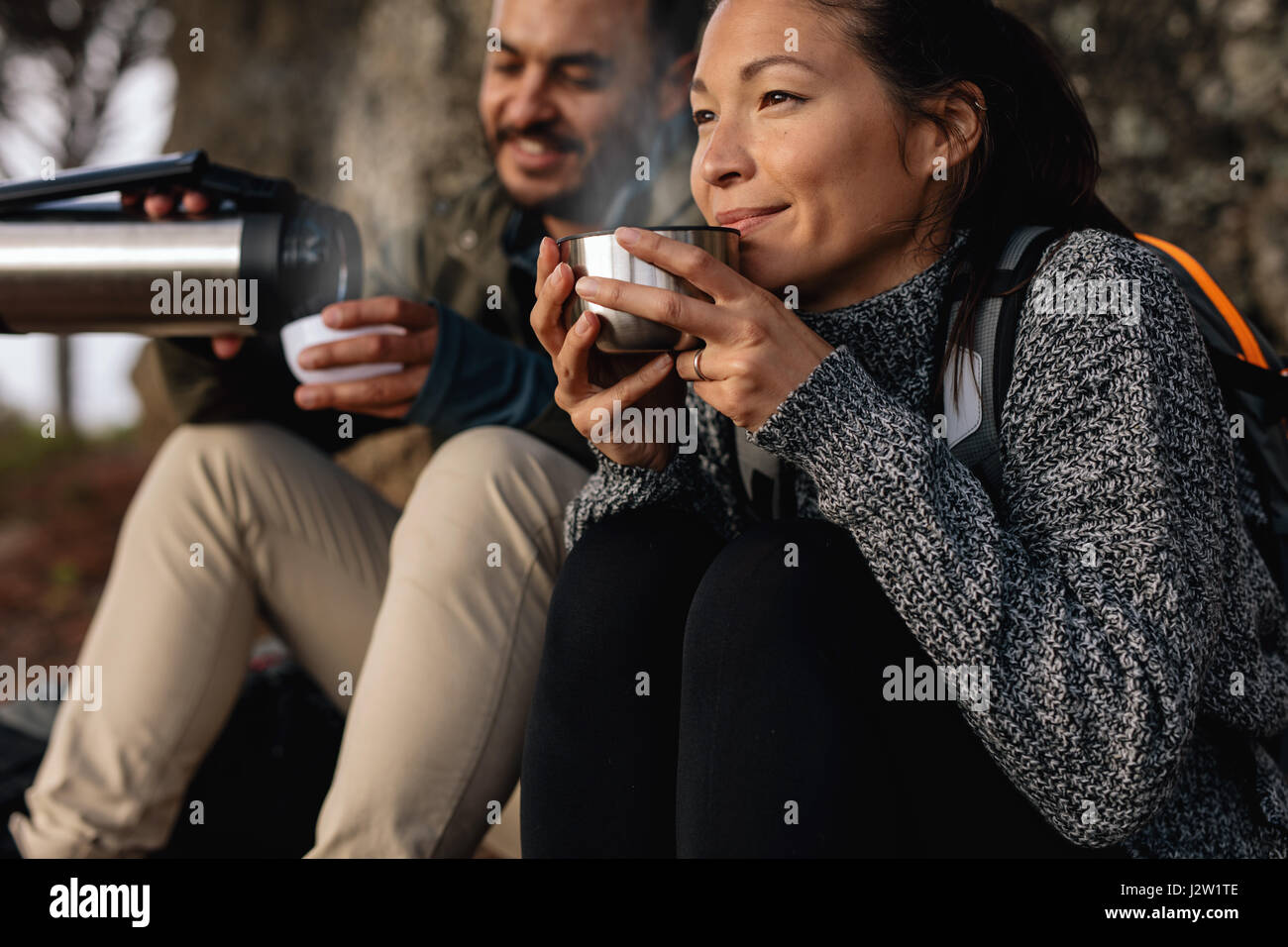 Jeune couple en faisant une pause sur une randonnée. L'homme et de la femme de boire du café pendant la randonnée. Banque D'Images