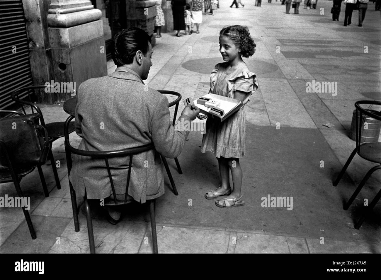 Une photographie intitulée "Angela vend des cigarettes, Naples 1948" capture un moment dans l'Italie d'après-guerre, où Angela est vue vendre des cigarettes dans une scène de rue, reflétant la vie quotidienne à Naples à la fin des années 1940 Banque D'Images
