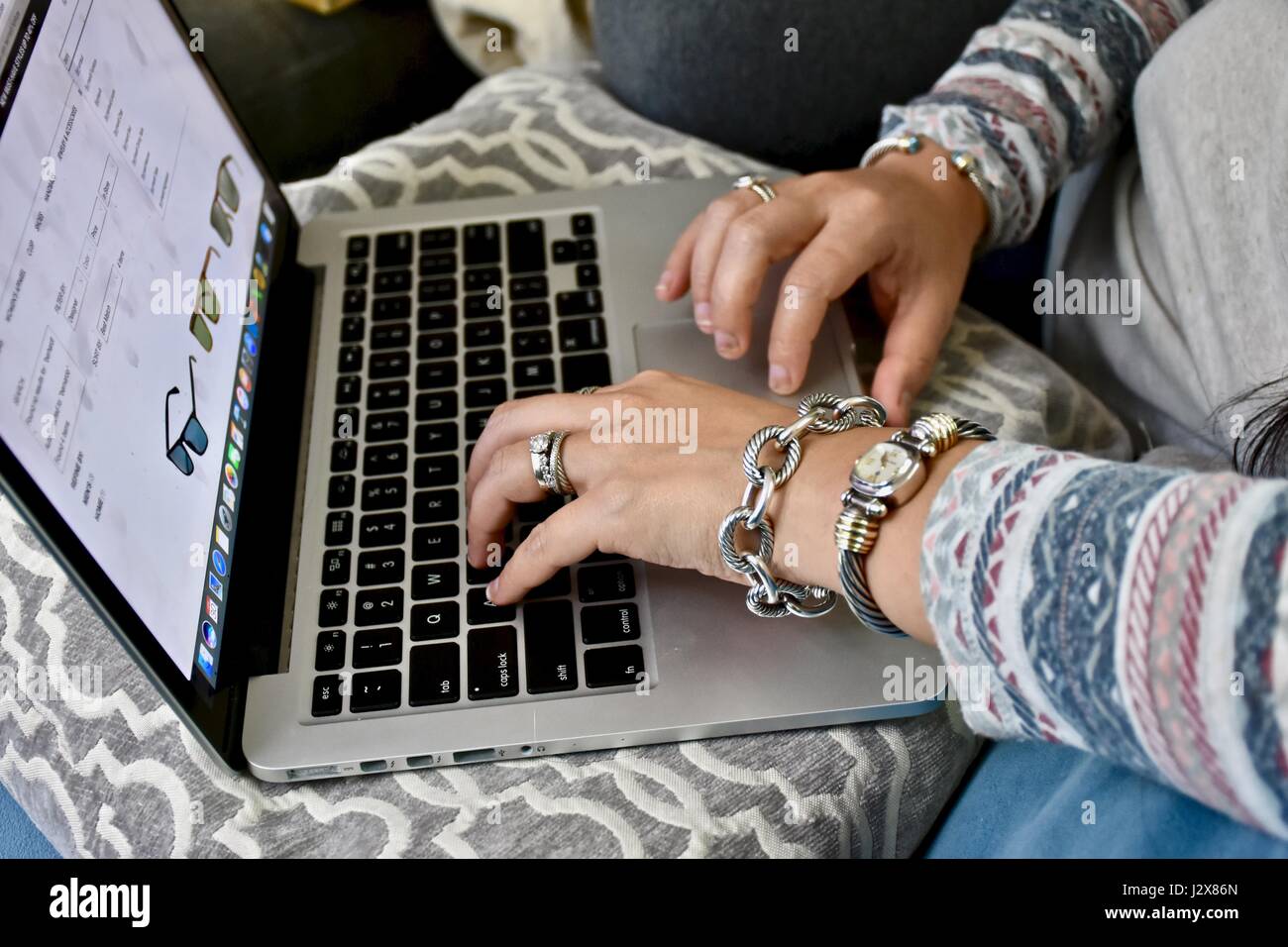 Femme portant des bijoux David Yurman taper sur Apple Macbook Pro Banque D'Images