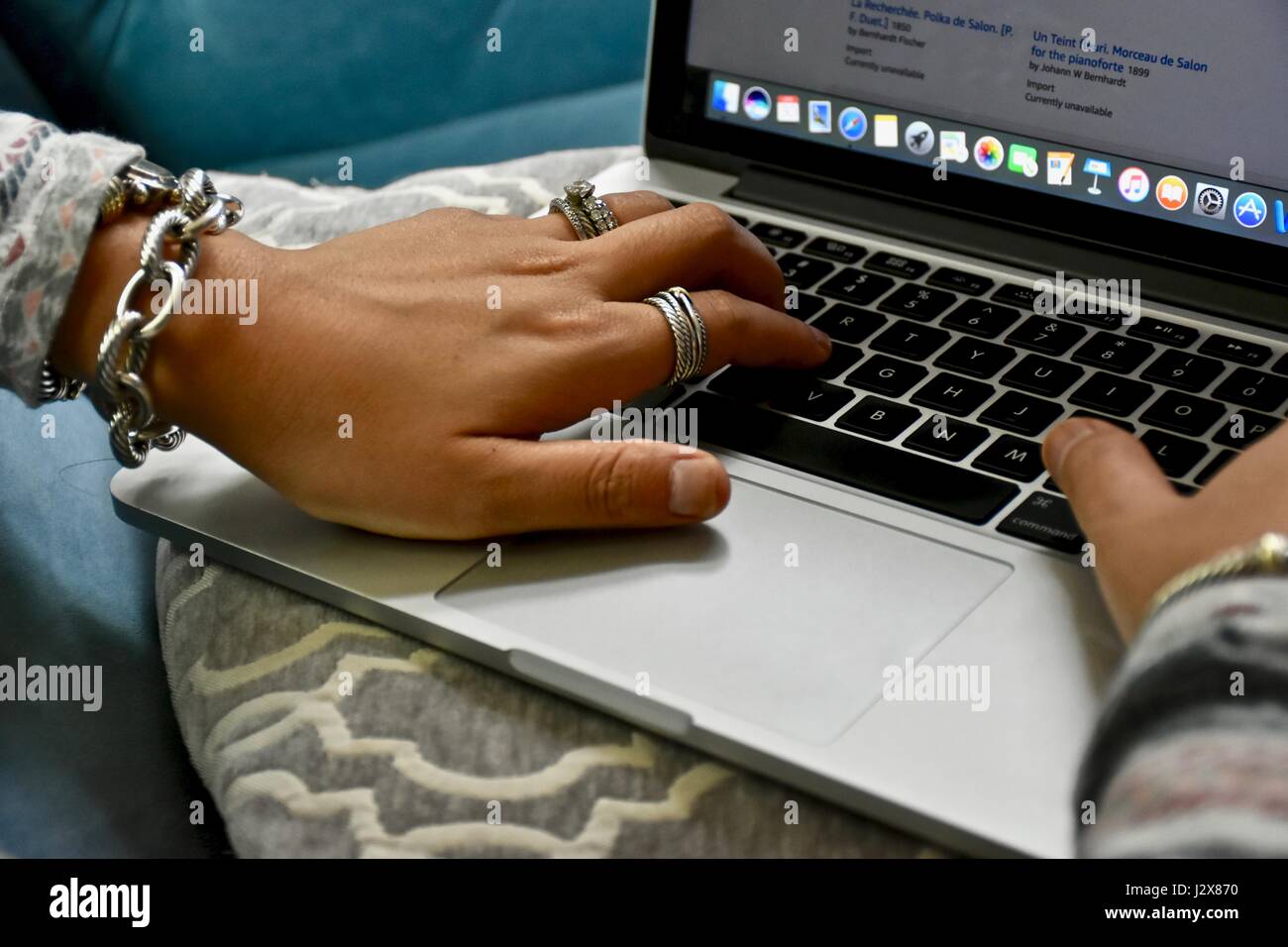 Femme portant des bijoux David Yurman taper sur Apple Macbook Pro Banque D'Images