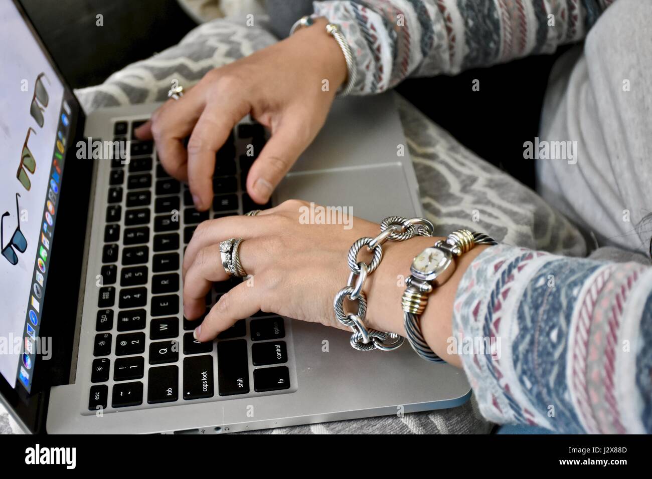 Femme portant des bijoux David Yurman taper sur Apple Macbook Pro Banque D'Images