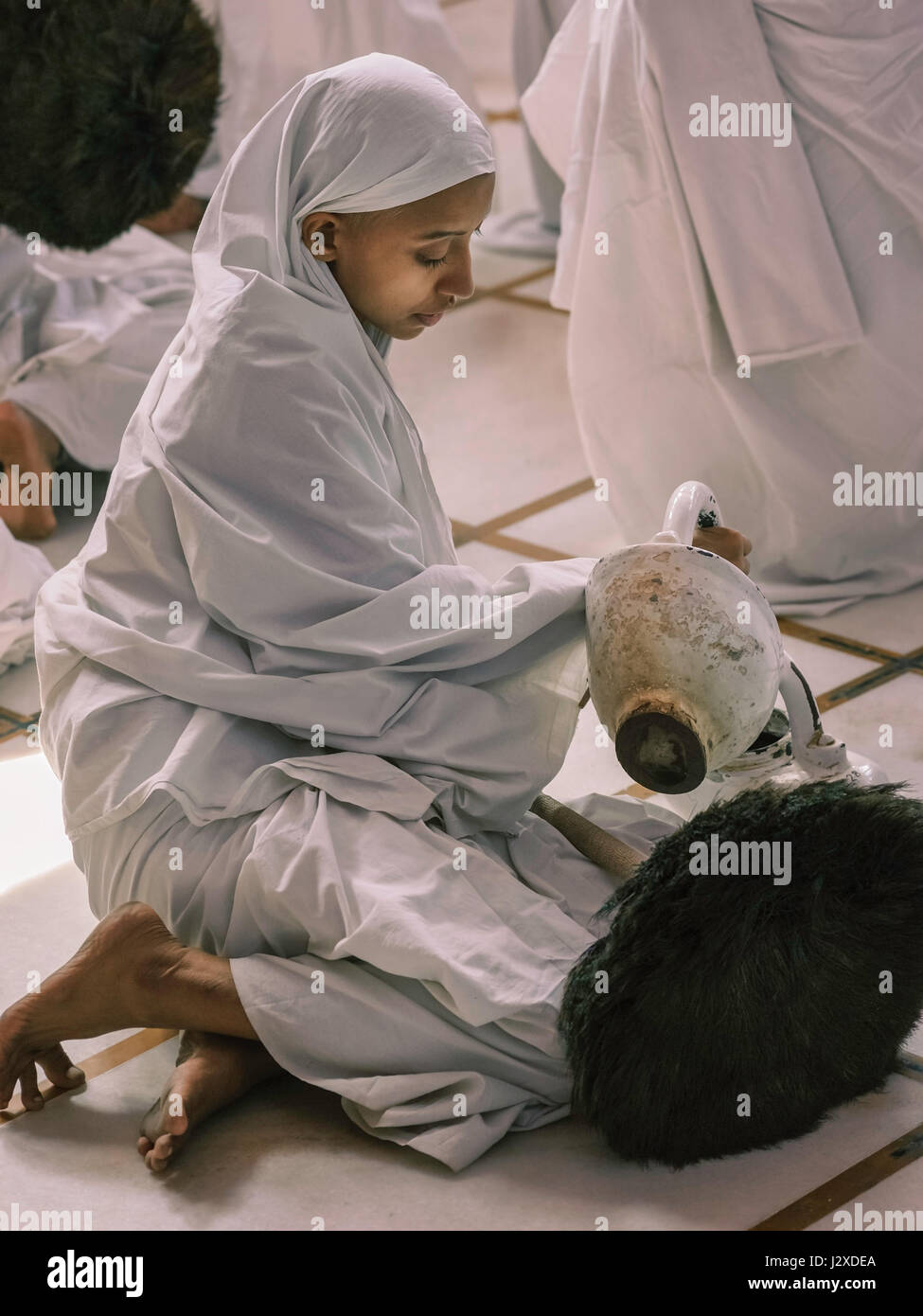 Un Jain nun pendant le festival Chaturmas avec brosse de plume de paon et pot à l'eau Digambara temple à Ajmer, Rajasthan, Inde. Banque D'Images