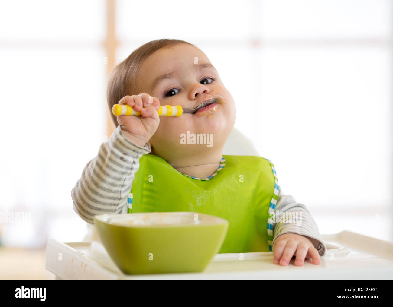 Happy Baby Boy spoon mange lui-même Banque D'Images