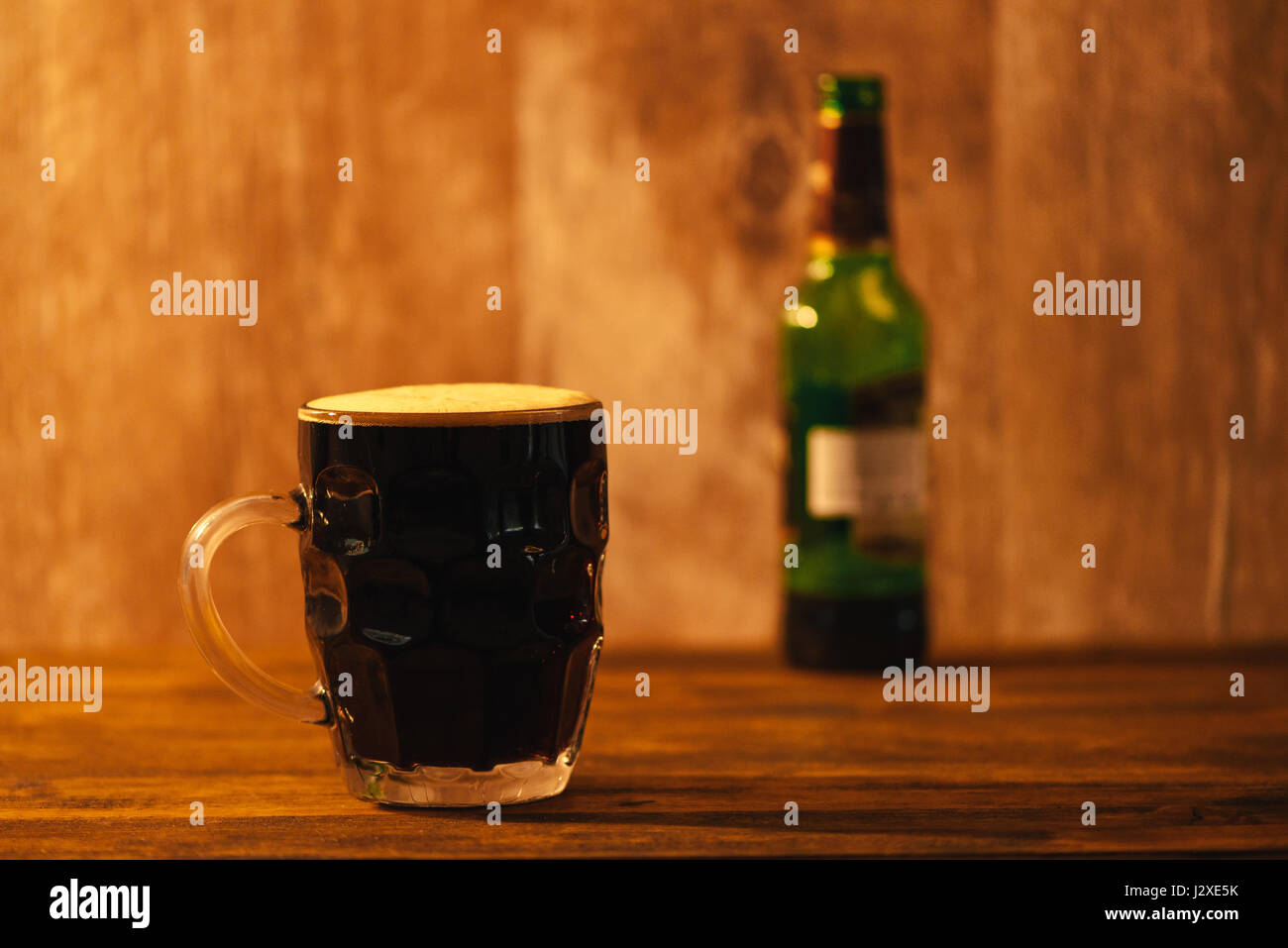 Bière brune de la pinte chope en verre à bosses sur un bar Banque D'Images