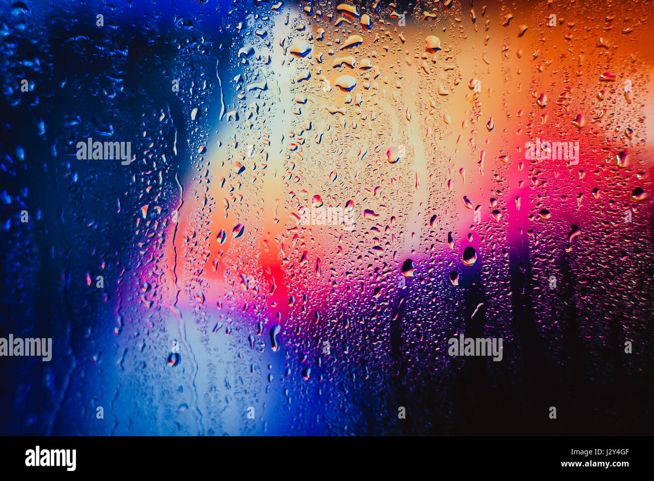 Gouttes de pluie sur un fond multicolore brouillée. Banque D'Images