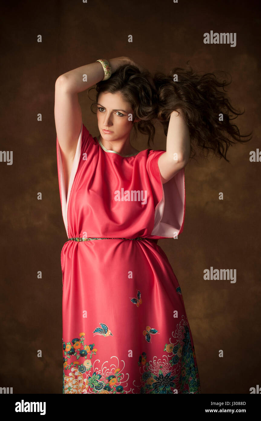 Belle jeune femme brune mains tenant de longs cheveux noirs à l'écart Banque D'Images