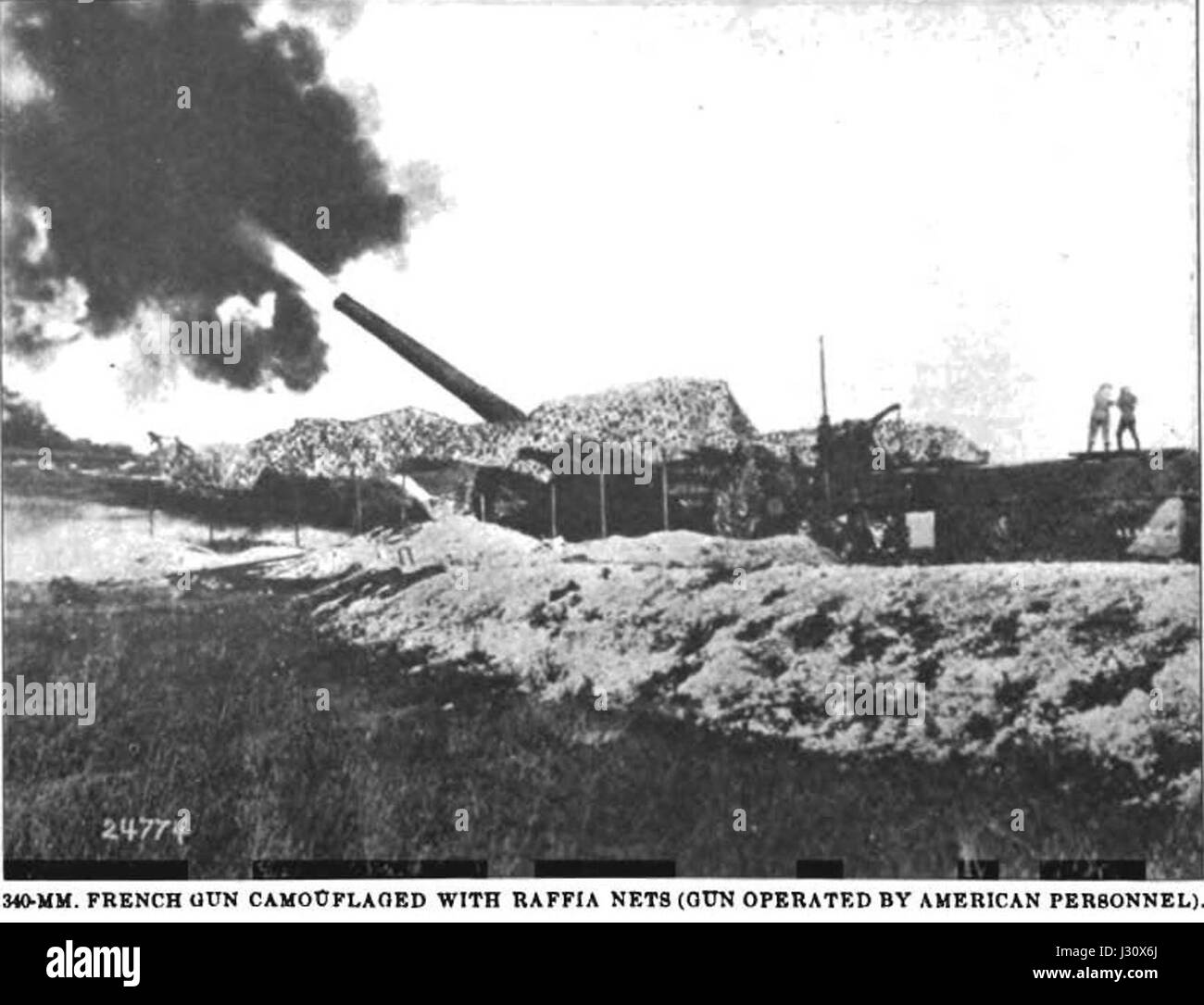 Cette image historique montre un canon ferroviaire français de 340 mm en action. Le canon, camouflé pour les opérations militaires, a été utilisé au début du XXe siècle. Il a été conçu pour les tirs d'artillerie lourde et a joué un rôle important dans les batailles, en particulier dans la première Guerre mondiale Banque D'Images