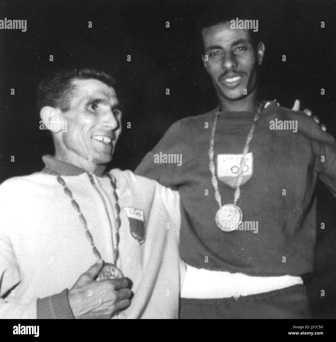 Rhadi Ben Abdesselam, du Maroc, et Abebe Bikila, de l’Éthiopie, sont représentés sur cette photographie de 1960, marquant des moments clés des Jeux Olympiques. Abdesselam a remporté l'or dans le relais 4x400m, tandis que Bikila a triomphé dans le marathon, remportant la victoire pieds nus. Banque D'Images