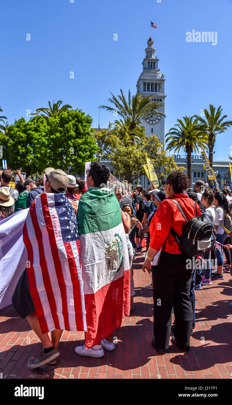 San Francisco, Californie, USA. 1er mai 2017. Deux jeunes hommes se portant des drapeaux comme capes, l'une portant un drapeau américain et l'autre un drapeau mexicain, comme la foule rassemblée le 1 mai 2017, à Justin Herman Plaza avant la "journée sans immigrés" en mars à San Francisco Market Street's Civic Center Plaza. Des milliers à San Francisco s'est joint à plus de 40 autres villes à travers les États-Unis pour protester contre les politiques d'immigration Donald Trump et soutenir les droits des immigrants. Credit : Shelly Rivoli/Alamy Live News Banque D'Images