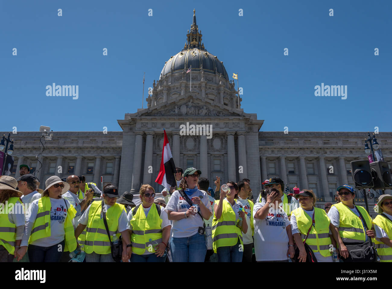 San Francisco, Californie, USA. 1er mai 2017. Ambassadeurs de la paix 'volontaire', en face de l'Hôtel de ville de San Francisco à la fin de la journée sans immigrés de San Francisco en mars. Dans l'arrière-plan est le drapeau du Yémen, tenue par l'un de nombreux immigrants en provenance de pays à travers le monde qui ont participé au rallye et mars. Le 1 mai 2017, plus de 40 villes aux États-Unis ont organisé des manifestations de protestation pour la 'journée sans un immigrant.", à San Francisco, des milliers de personnes sont descendues dans les rues pour protester contre l'atout politique d'immigration. Credit : Shelly Rivoli/Alamy Live News Banque D'Images