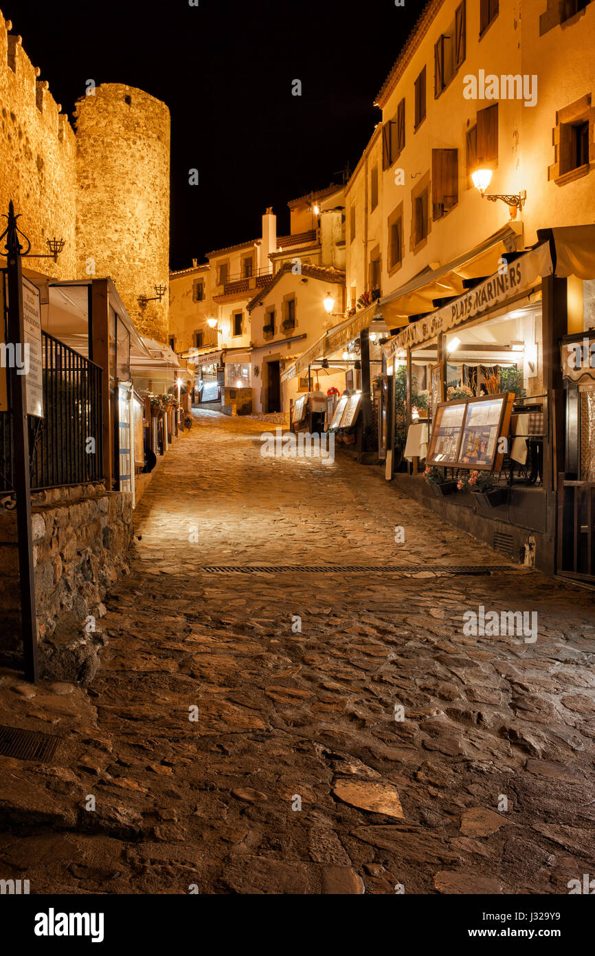 L'Espagne, Tossa de Mar la nuit, ruelle pavée avec des restaurants, des cafés à côté de la vieille ville (Vila Vella), Costa Brava, Catalogne région. Banque D'Images