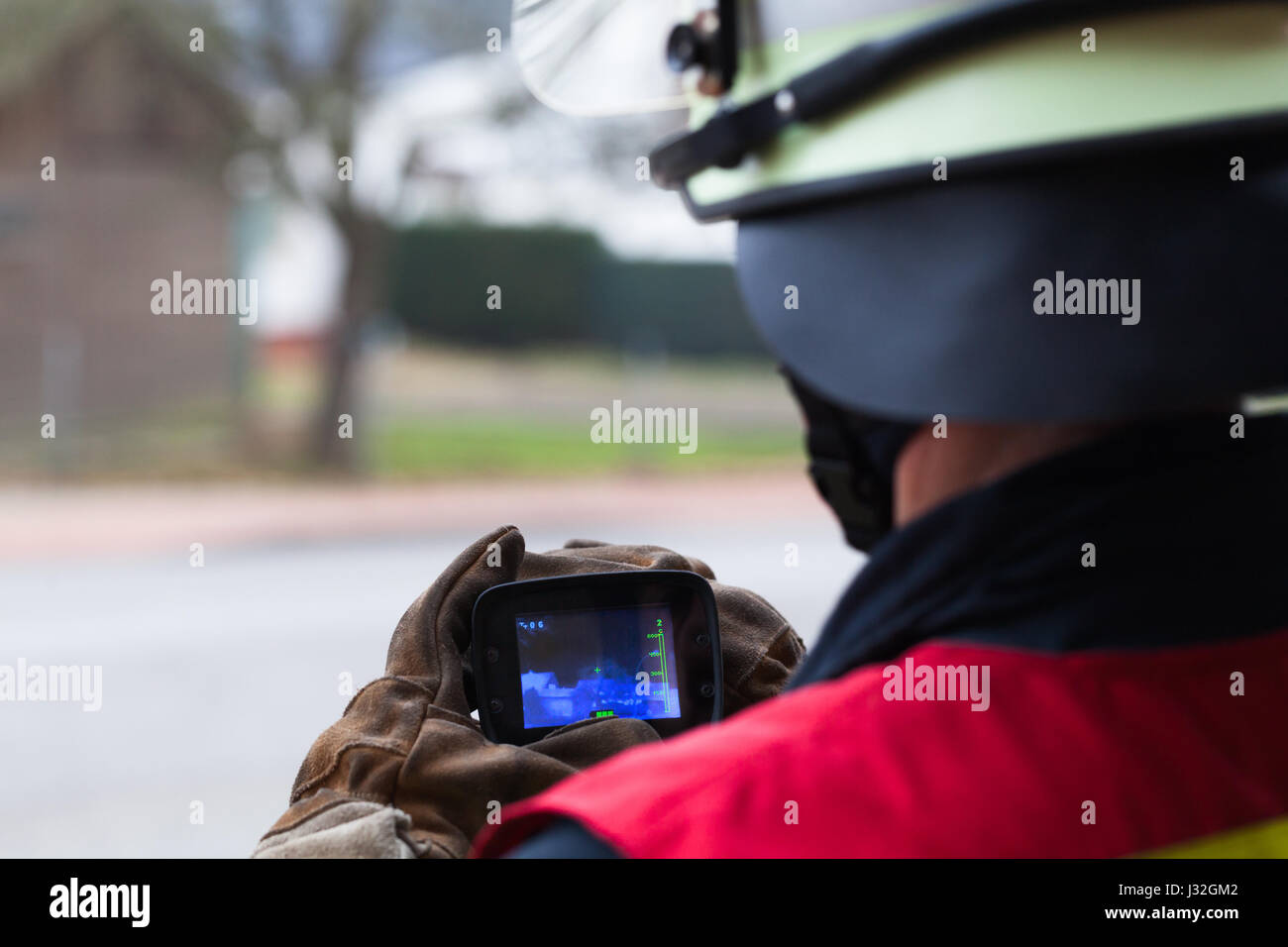 L'allemand pompier dans une action avec une caméra à imagerie thermique Banque D'Images