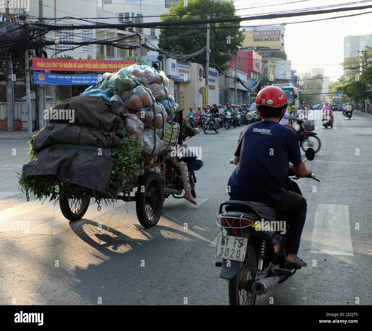 Ho Chi Minh ville, Viet Nam, transport surchargé en moto sur la rue vietnamienne, couple ride moto, pas la sécurité routière, Vietnam Banque D'Images