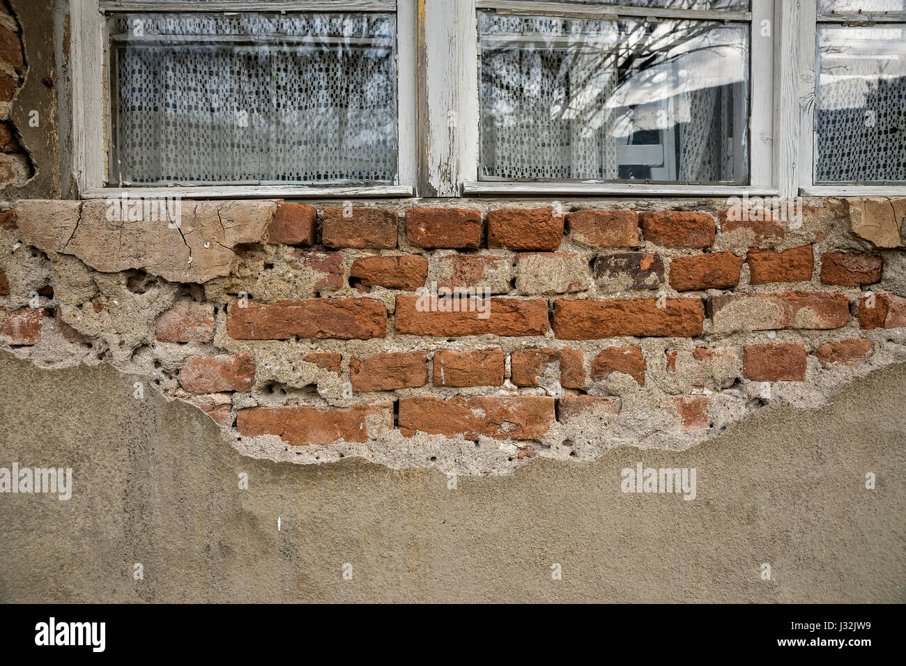 Les briques dans le mur d'un vieux bâtiment en ruine avec de vieilles fenêtres Banque D'Images