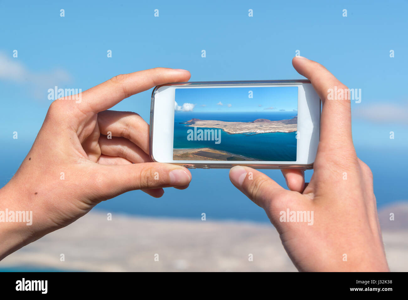 Close up sur mains tenant un smartphone pour prendre des photos, à Lanzarote, Espagne Banque D'Images