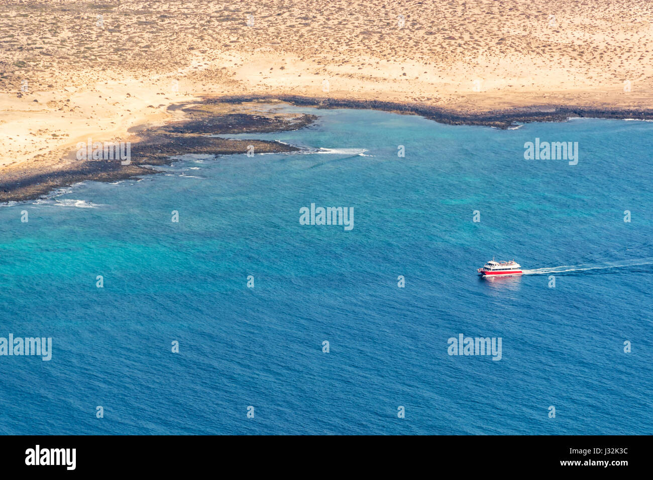 Vue aérienne d'un bateau dans l'océan avec la côte de la Graciose dans l'île de Lanzarote, îles Canaries, Espagne Banque D'Images
