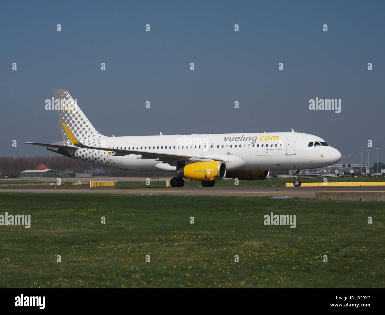L'image montre un Airbus A320-232(WL) exploité par Vueling Airlines, atterrissant à l'aéroport de Schiphol (AMS) aux pays-Bas. L'avion fait partie de la flotte utilisée pour les vols régionaux et internationaux. Banque D'Images