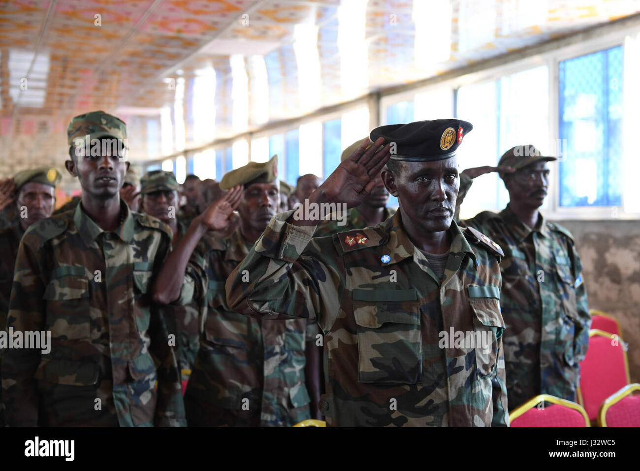 L'armée nationale somalienne (SNA) les saluent comme ils chantent l'hymne national de la Somalie au cours d'une cérémonie de passage pour marquer la fin d'un cours de formation militaire menée par la Mission de formation de l'Union européenne en Somalie (EUTM) à l'Dhegabadan Training Camp (Jazeera) à Mogadiscio, Somalie, le 14 janvier 2017. L'AMISOM Photo / Omar Abdisalan Banque D'Images