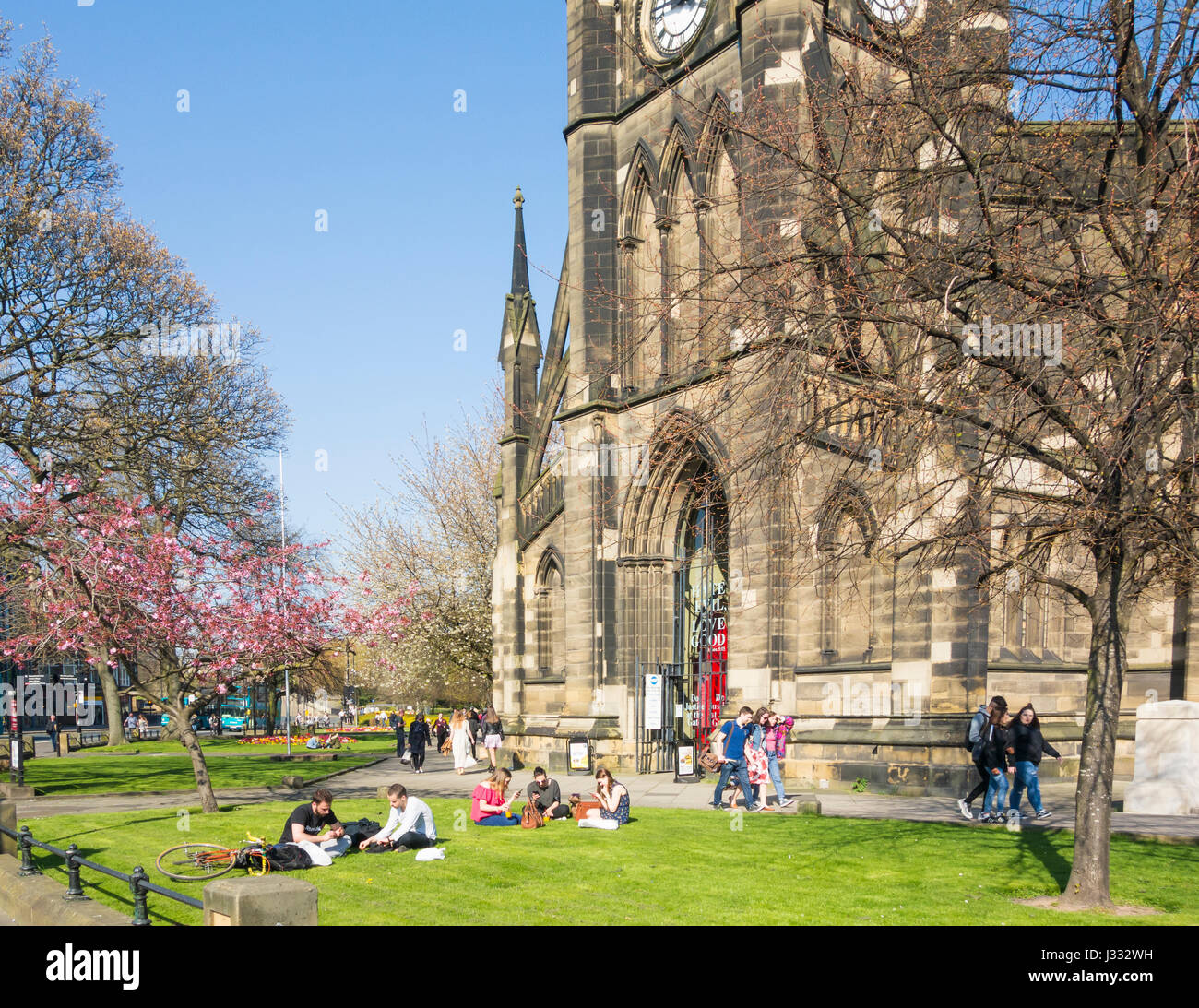 Les élèves assis sur l'herbe à l'extérieur de l'église de St Thomas le Martyr près de Newcastle/Northumbrie univerites, Newcastle upon Tyne, Angleterre. UK Banque D'Images