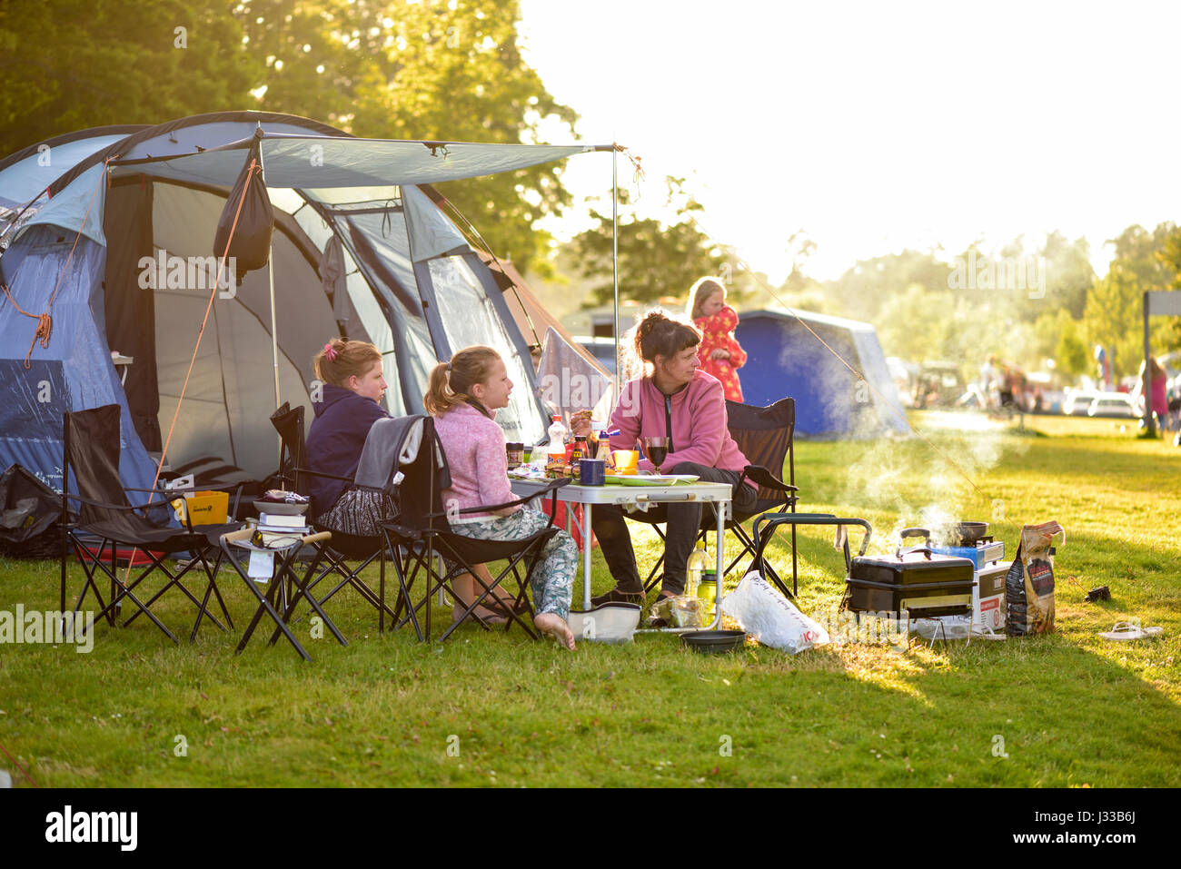 Camping familial, la mère et les deux filles avec un barbecue en face de tente, camping, Porto, Smaland, Suède Banque D'Images