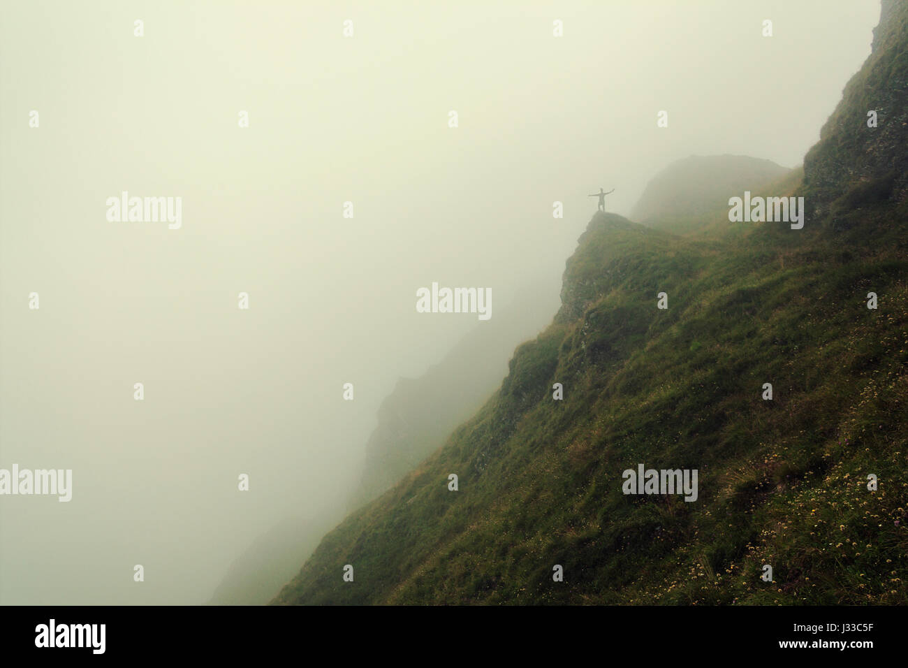 Randonneur debout sur un rocher, entouré de brouillard dans les montagnes Pfunderer, Tyrol du Sud, Italie Banque D'Images