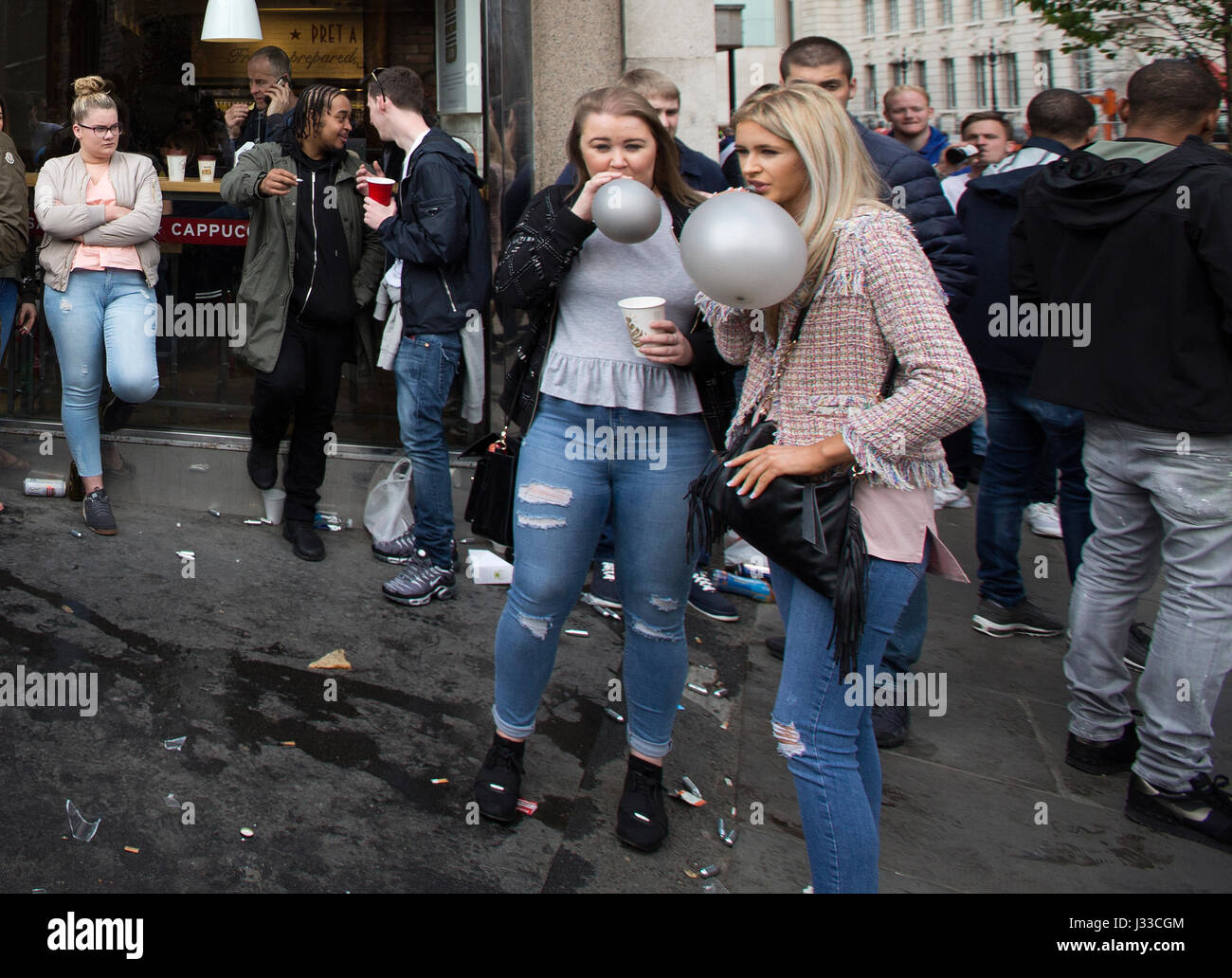 Les jeunes dans les rues de Londres en tenant euphorisants légaux, reniflant de protoxyde d'azote inhalé en ballons, Tower Bridge, London, UK Banque D'Images
